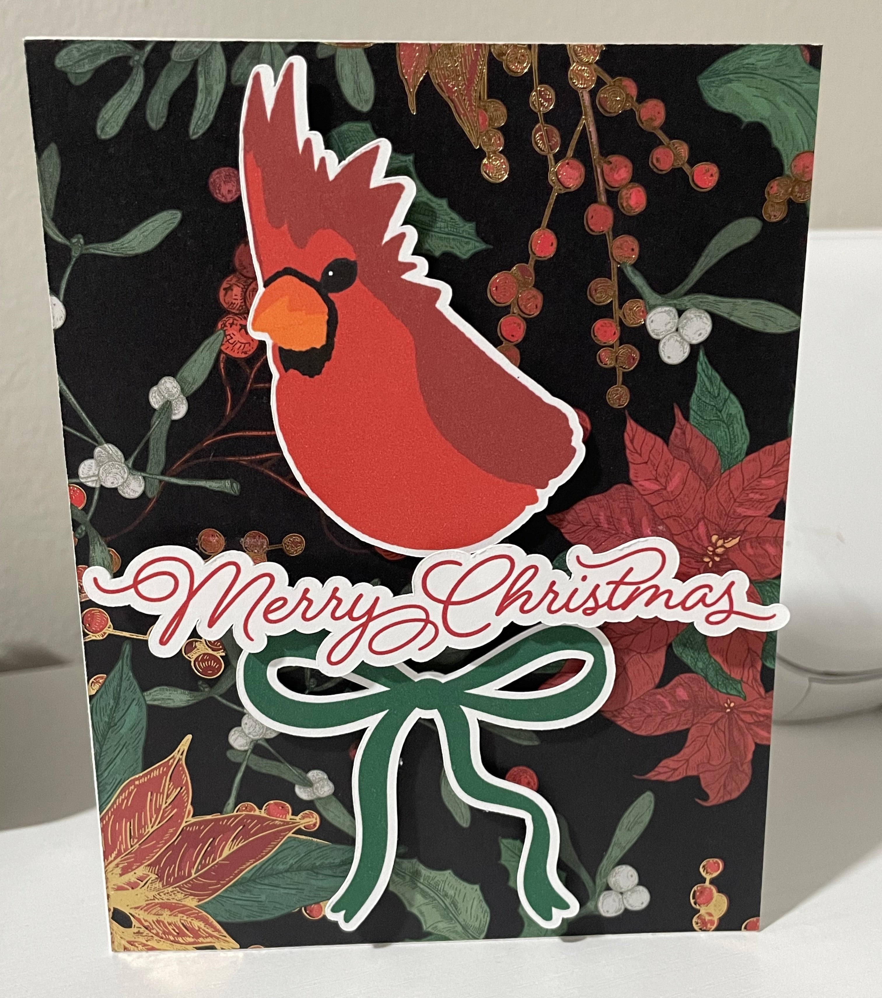 Christmas card with cardinal bird, wreath, and 'Merry Christmas' text on a dark background.